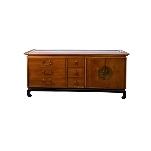 A beautifully crafted Kent-Coffey “Amerasia” walnut triple dresser with its original matching mirror, an iconic Mid-...