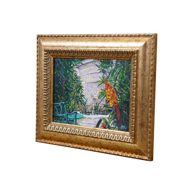 Late 20th century oil on board painting of a marble lion head fountain surrounded by tropical plants and a green bench....