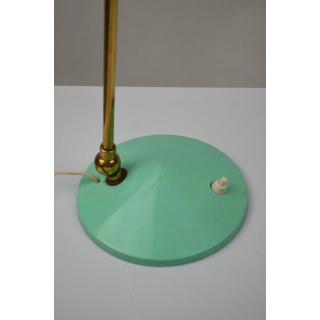 Elegant Italian desk lamp from the 1950s, representative of post-war modernist design. Its metal shade in original mint-...