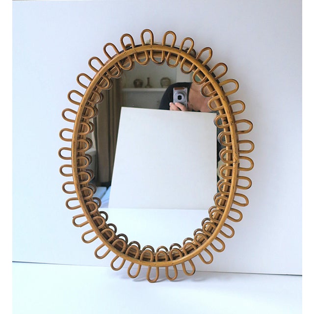 An Italian wicker rattan wall mirror in the style of designer, Franco Albini, by Rosenthal-Netter, circa mid-20th century,...