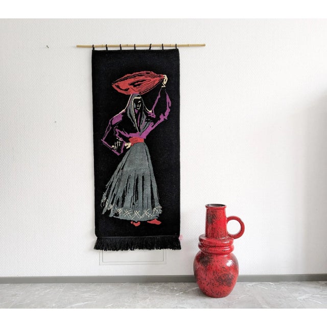 This tapestry from the 1960s is a large wall hanging with a female motif. The timeless color combination and size create a...