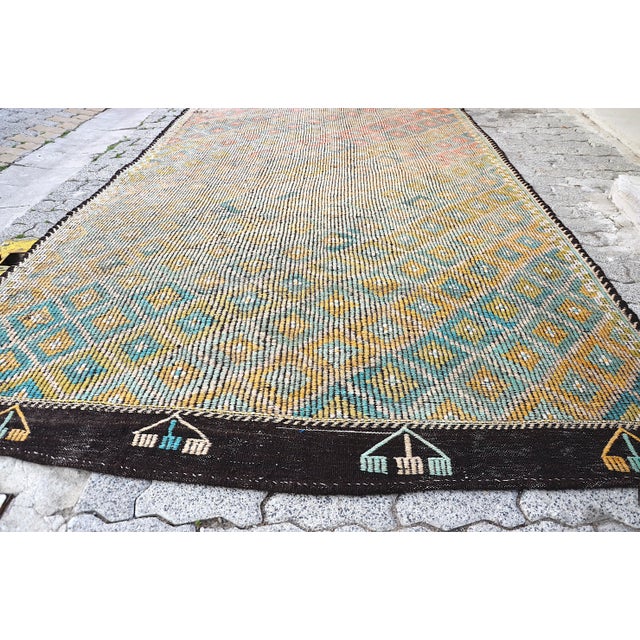 This is a vintage Turkish Anatolian kilim rug from the 1960s. The piece was hand-woven.