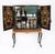 A fabulous vintage polychromed black lacquered and marquetry inlaid cocktail cabinet-on-stand, circa 1930 in date. The...