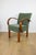 Bent vintage Art Deco loft armchair in olive green. A stylish, curved chair with a vintage Art Deco design, perfect for...