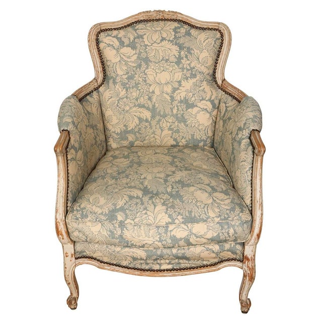 Elegant pair of French Louis XV style bergère chairs featuring gracefully curved frames with a softly distressed painted...