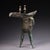 This is a cast bronze tripod vessel, featuring a distinctive form with a long, pointed spout, an upturned tail, and two...