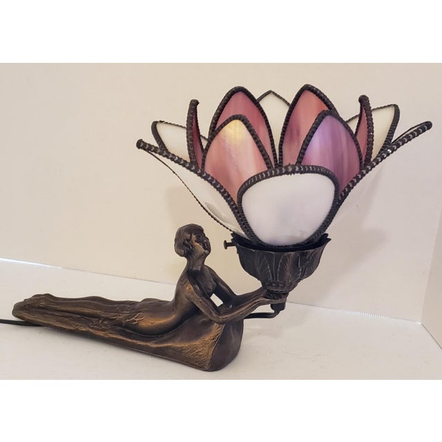 An exceptionally evocative Art Deco figural table lamp featuring a graceful reclining nude supporting a spectacular lotus-...