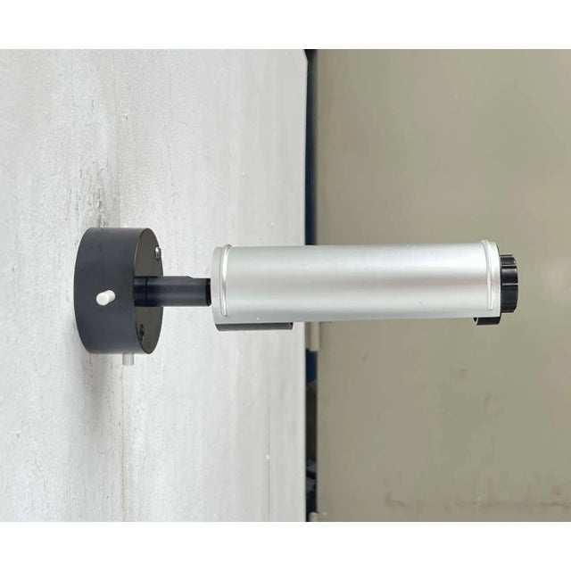 Minimalist wall light from the German manufacturer Erco. The light features a simple cylindrical shape. Its distinctive...