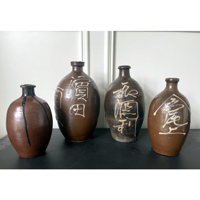 A set of four Japanese Ceramic Tokkuri Sake storage bottles circa early 20th century (Meiji to Taisho period). The bottles...