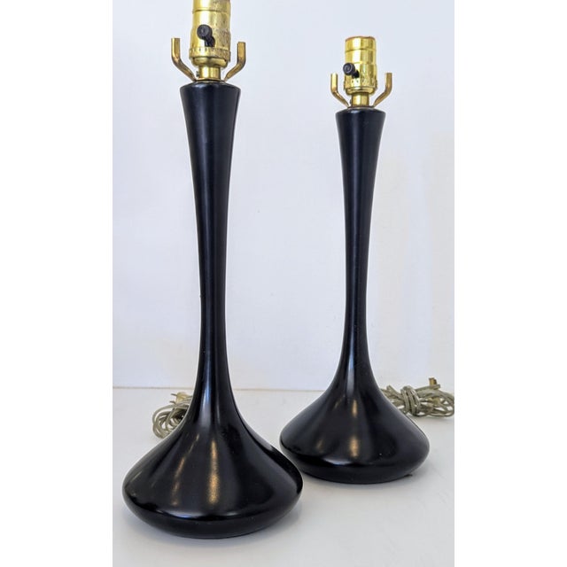 An elegant, sculptural pair of Mid-Century table lamps by the Laurel Lamp Company, featuring matte black goblet-shaped...