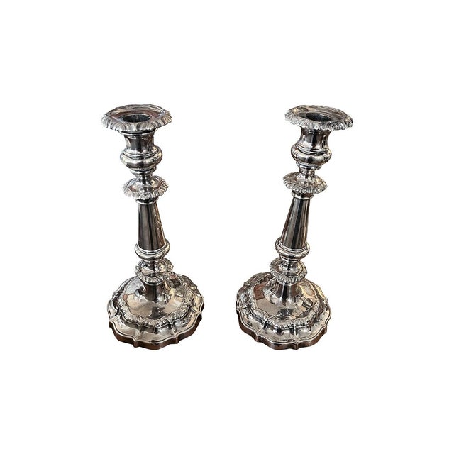 This is a pair of English modern classical candlesticks that are silver-plated, with substantial round bases. They feature...