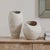 This Pair Of Earthenware Vases Is Covered In A Creamy White Finish With Subtle Blue And Rust Brushstrokes For Added...