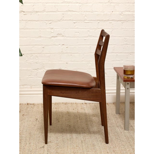 A handsome set of four vintage Danish modern dining chairs crafted in richly toned rosewood. Each chair features a...