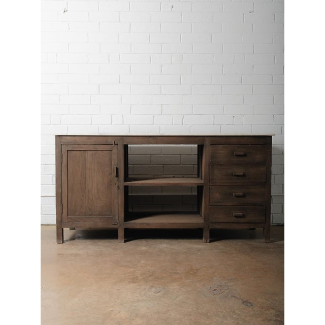 This substantial wooden sideboard from India dates to the 20th century and features a beautiful combination of natural...