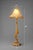 A dramatic 38-inch Hollywood Regency style table lamp featuring a solid cast iron base, carved column detail, dual tassel...