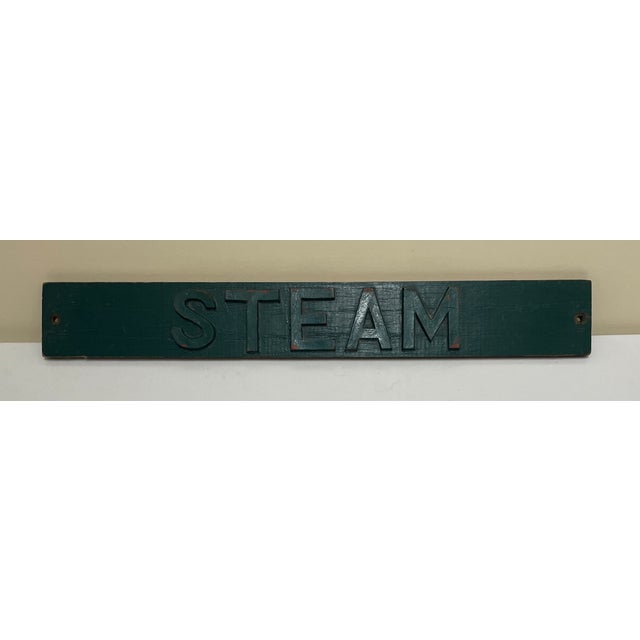 1920s industrial sign reading "STEAM." Wooden cut out letters mounted to a wooden strip and painted a color somewhere the...