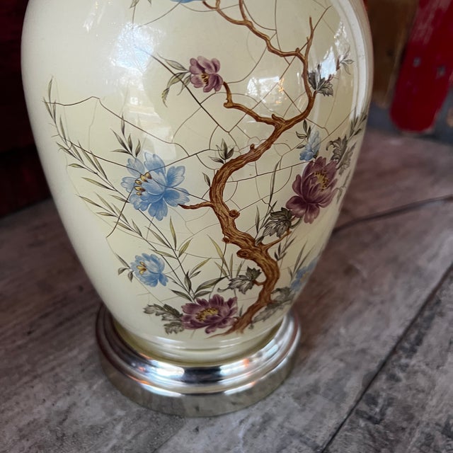 This vintage 14-inch table lamp features a crackle-glazed ceramic base adorned with delicate floral designs and a metal...