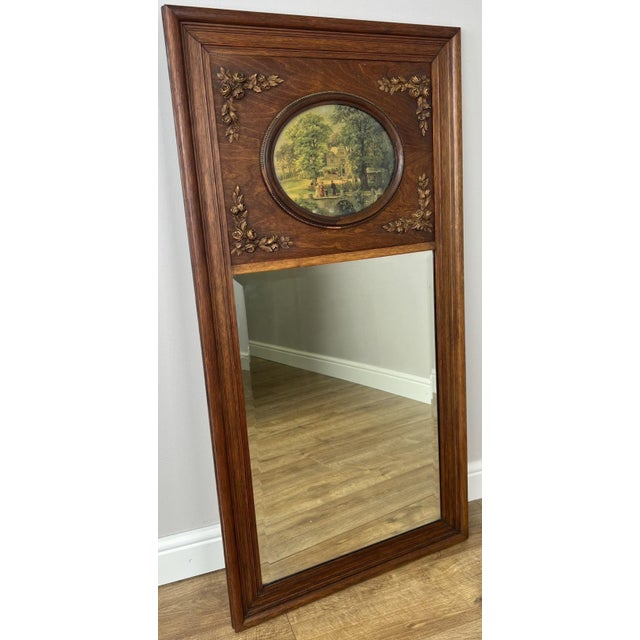 A beautiful Antique French polished mirror featuring a richly toned oak frame with elegant decorative floral...
