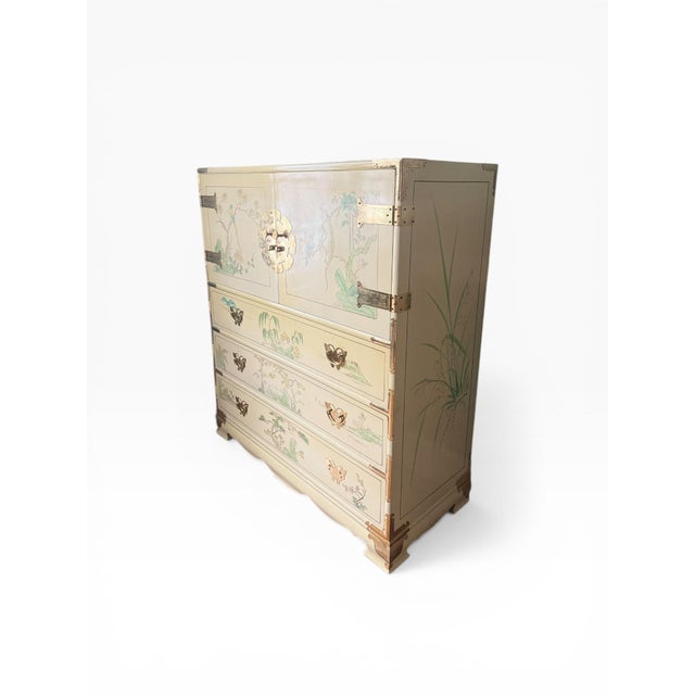 Vintage chinoiserie chest featuring a cream lacquered finish with hand-painted bird and landscape motifs throughout. The...
