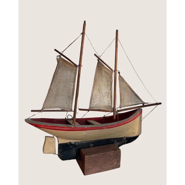 A hand-carved wooden ship model, beautifully aged and worn from time and touch. The linen sails have softened to a natural...