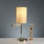 1980s-style table lamp with a swivel arm for directional and customizable lighting. The brass-plated metal frame lends a...