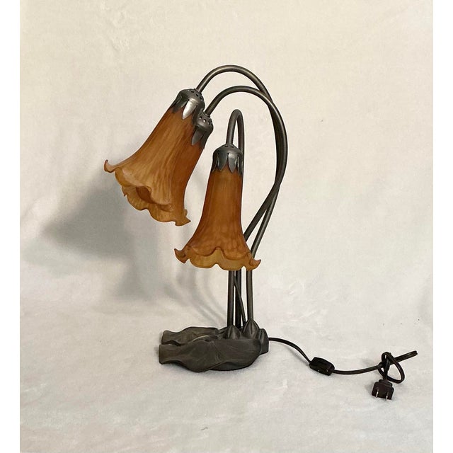 Tiffany styled lamp with lily shades on a lily pad bass. Recreated design from the early 1900s. Lily shades are mouth...