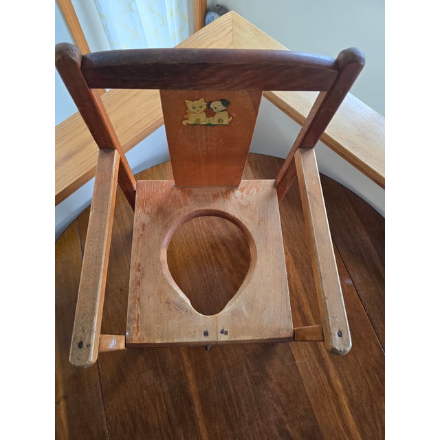 Sweet vintage wooden child's potty chair featuring an adorable original kitten and puppy decal on the backrest. The...