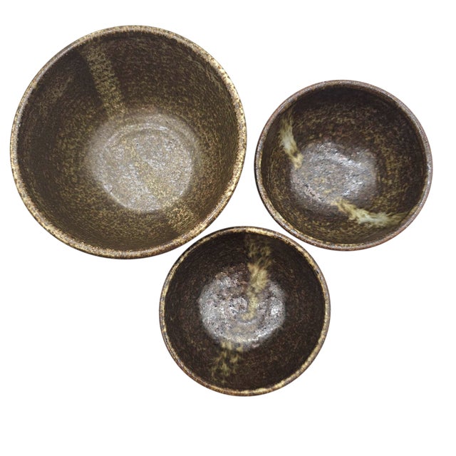 A group of three Japanese stoneware Chawan-style bowls produced in a late 20th-century Mingei folk-craft tradition. Formed...