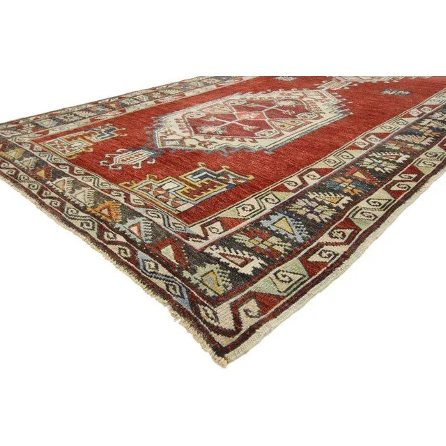 This hand knotted wool vintage Turkish Oushak Gallery rug features two hexagonal medallions with latch hook edges and...