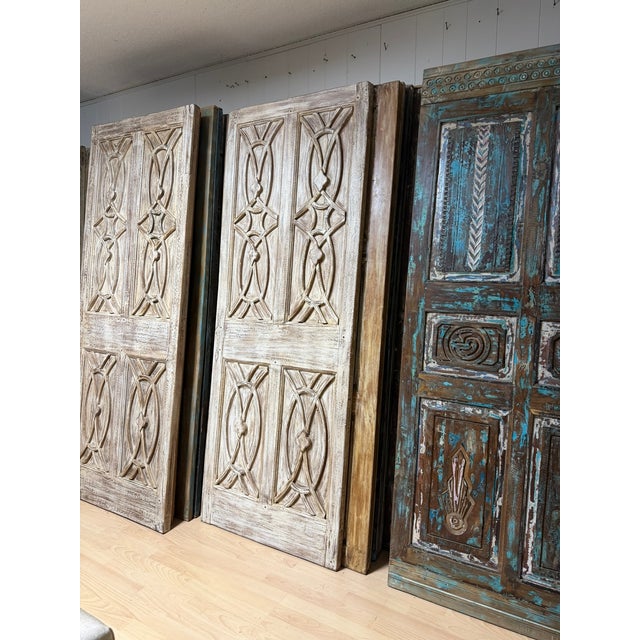 This striking pair of antique double entry doors is expertly hand-carved from solid wood and finished with a richly...