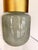 Contemporary decorative accent featuring an opalescent green glass vessel paired with a warm brass rim for a refined...