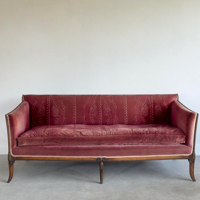 Wine-colored single-cushion velvet sofa. Features intricate stitching on cushion and back. Faded to a dusty rose in...