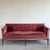Wine-colored single-cushion velvet sofa. Features intricate stitching on cushion and back. Faded to a dusty rose in...