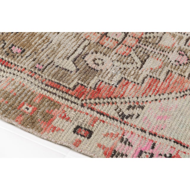 This is a vintage Turkish Oushak rug from the Mid 20th Century. The piece was hand-knotted.