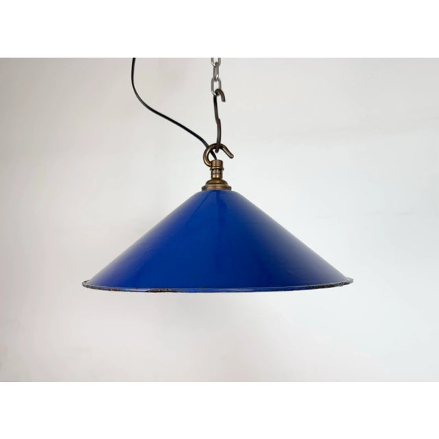 Industrial blue enamel factory pendant light made in United Kingdom during the 1950s. White enamel inside the shade. Brass...