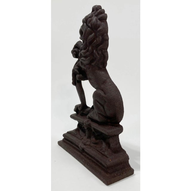 Large vintage cast iron doorstop featuring regal lion figure on podium. Very heavy with a great presence. Age wear.