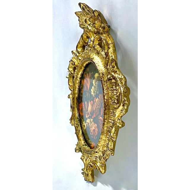 Vintage Florentine floral souvenir frame. Carved acanthus gilt wood oval frame with a print of a floral bouquet painting....