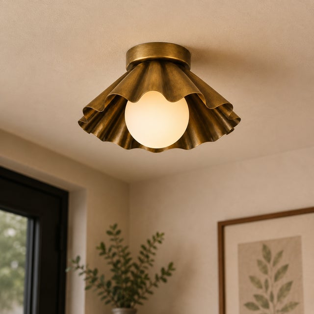 Crafted from solid brass, this sculptural flush mount ceiling light features a softly folded scalloped shade paired with...