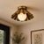 Crafted from solid brass, this sculptural flush mount ceiling light features a softly folded scalloped shade paired with...