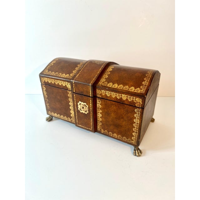 A charming vintage leather box, finely crafted in the form of a miniature treasure chest and finished in richly **gold-...