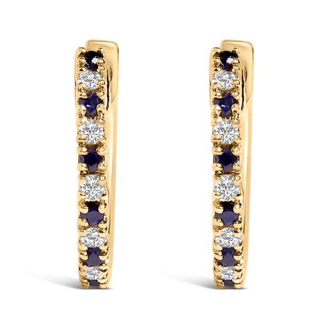 Indulge in the elegant harmony of brilliant blue sapphires and dazzling diamonds with these exquisite huggy hoop earrings,...