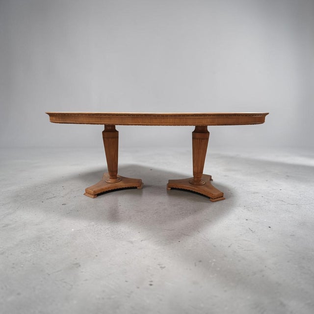 A large oval table made around the middle of the last century with details reminiscent of neoclassical lines....