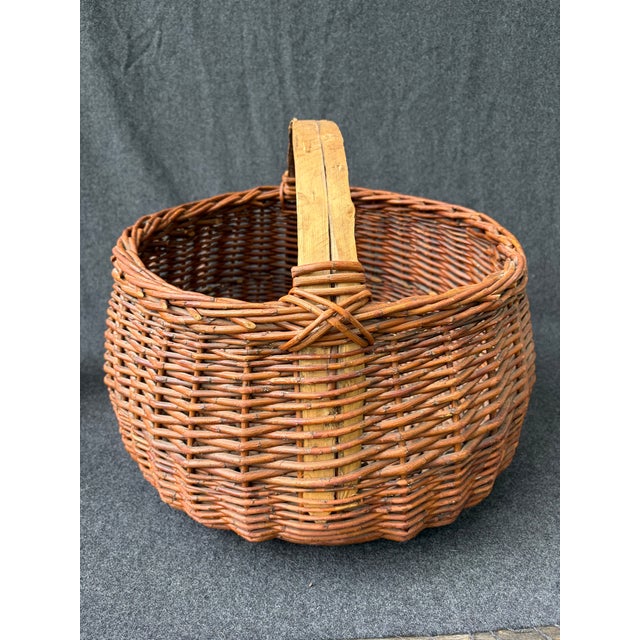Large antique hand woven willow basket with a top double spliced branch handle. There is a bit of loose bark on the...