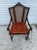 This stunning antique armchair features an intricately carved wooden frame with a unique cane backrest design that brings...