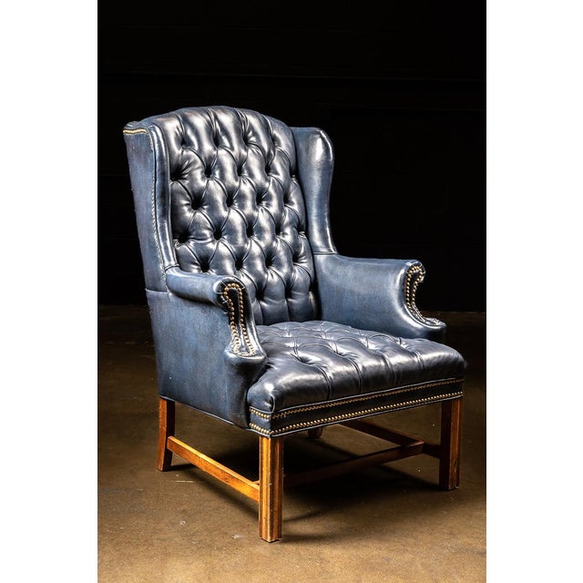 This gorgeous tufted leather chair boasts a rich midnight blue hue and gold accent buttons. Featuring a wide, comfortable...
