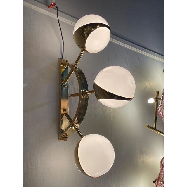 Gorgeous pair of modern Italian murano brass and ball form sconces. Makes a stylish statement!