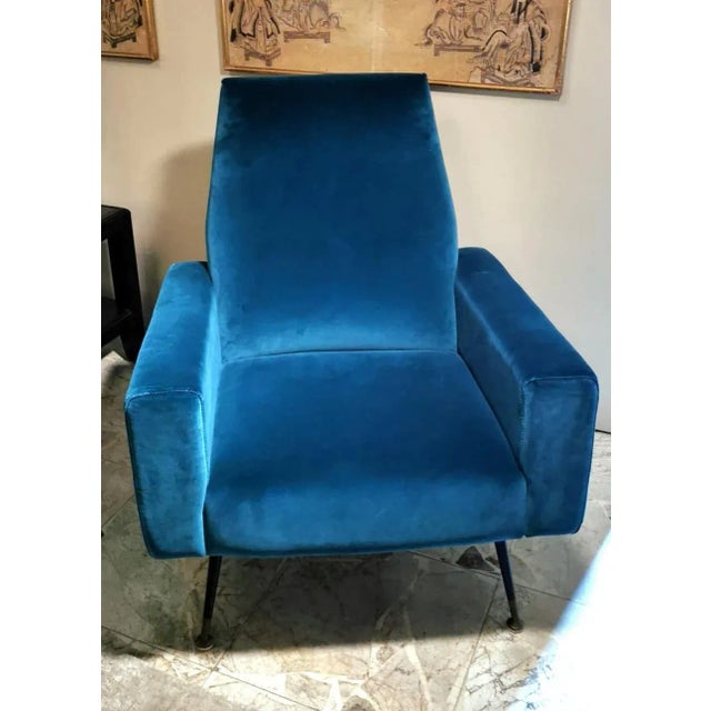 Comfortable upholstered armchair; the structure is very solid with black painted brass legs; the seat is large and...
