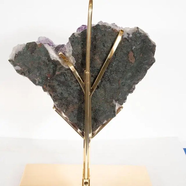 Single brass table lamp with custom frame supporting a massive heart-shaped natural amethyst fragment.