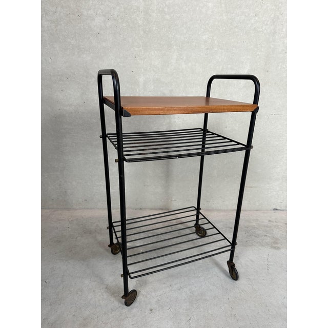 Nice table in metal and teak on wheels. 1960s/70s. Nice condition. Dimensions: 39 x 28 x 66.5 cm.