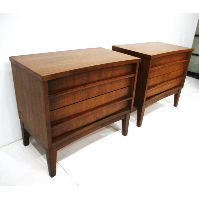 A nice pair of walnut nightstands with a gently curved front having long sweeping pulls giving the pieces a sophisticated...